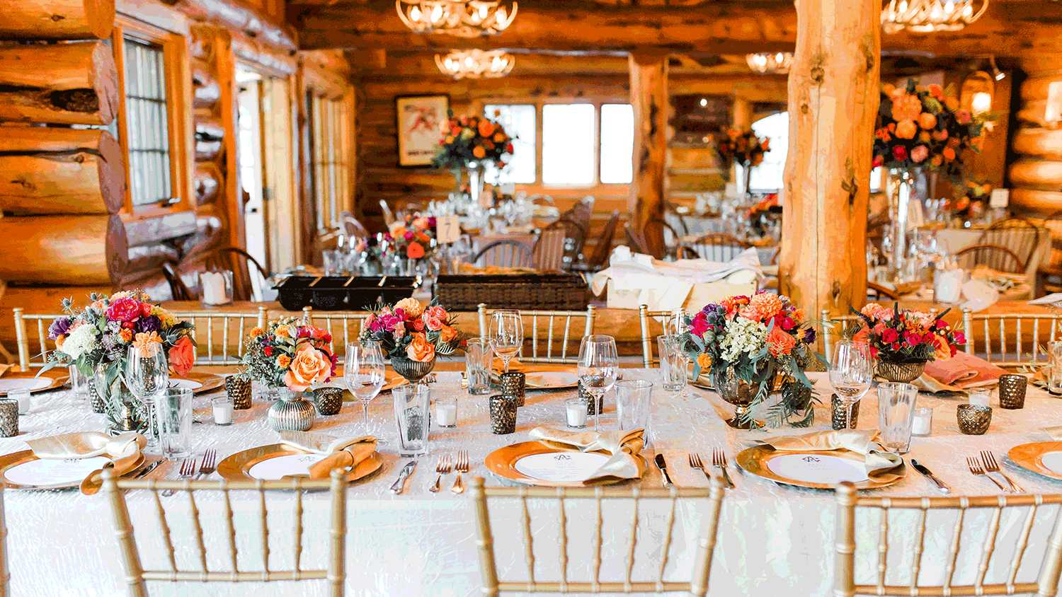 Pine Creek Cookhouse dressed for an elegant private event &mdash; gold chiavari chairs and floral centerpieces.